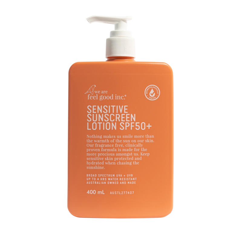 Orange bottle of sensitive sunscreen lotion with pump on a white background