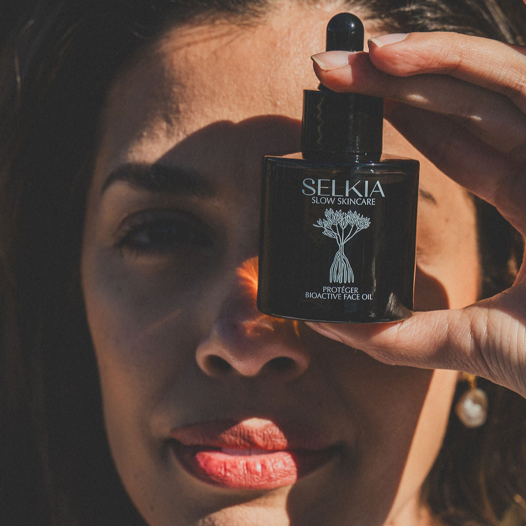 holding a bioactive face oil over womans eye