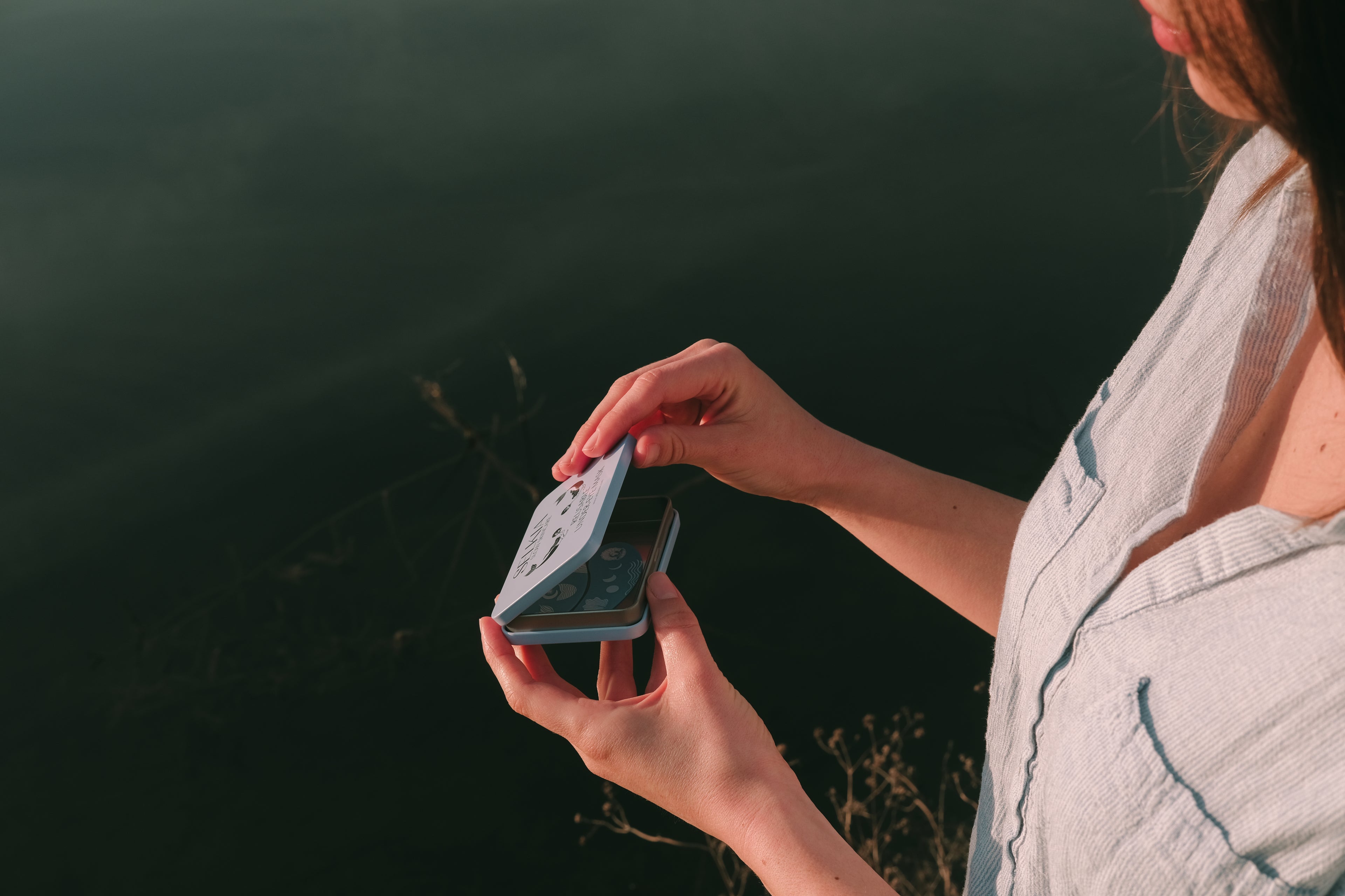 Person holding a small rectangular object against a dark background